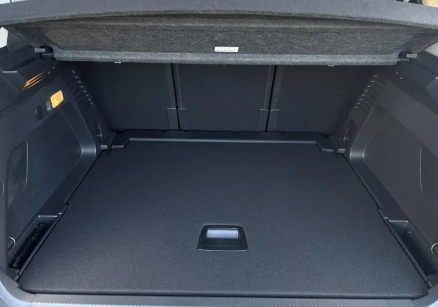 Coffre ouvert du Citroën C5 Aircross gris Platinium, montrant le plancher plat et la trappe de rangement intégrée.