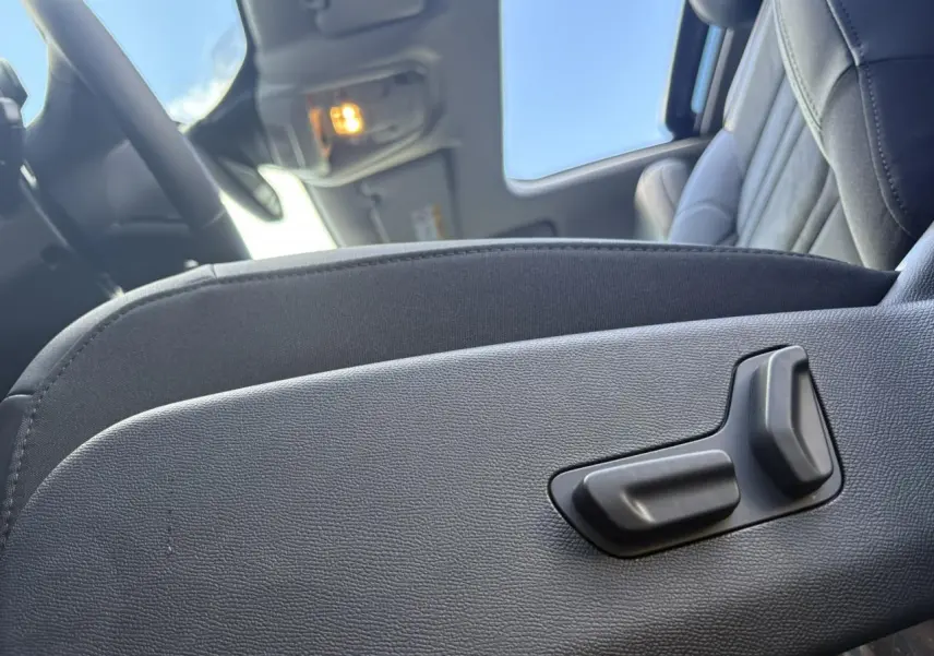 Détail des commandes électriques du siège conducteur noir Alcantara dans l'habitacle du Citroën C5 Aircross 2025.