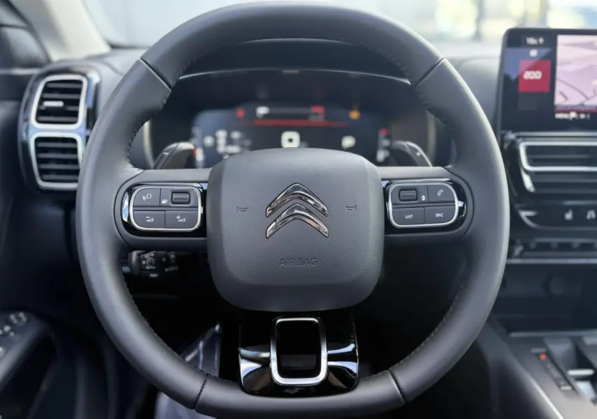 Volant en cuir noir de Citroën C5 Aircross 2025 avec commandes intégrées et tableau de bord numérique en arrière-plan