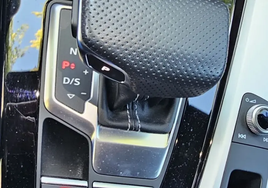 Gros plan sur le levier de vitesses automatique en cuir perforé noir de l'Audi A5 Sportback 2022, console brillante.