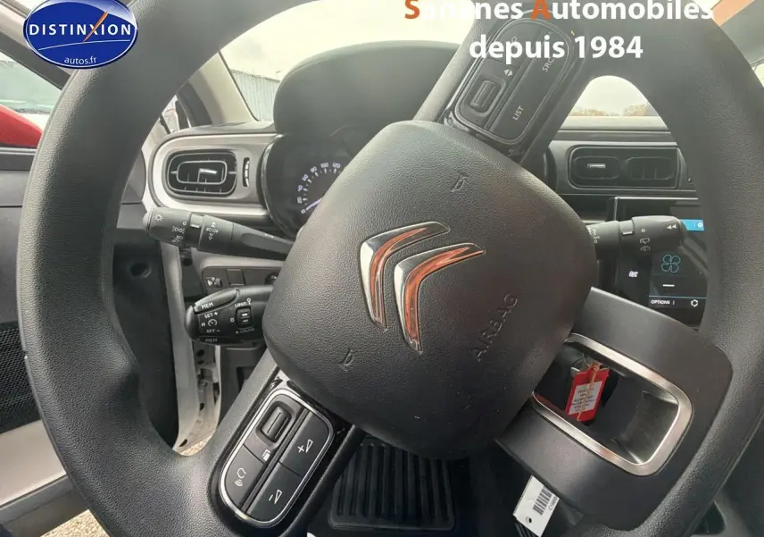 Vue rapprochée du volant Citroën C3 2021 avec commandes intégrées et tableau de bord partiellement visible.