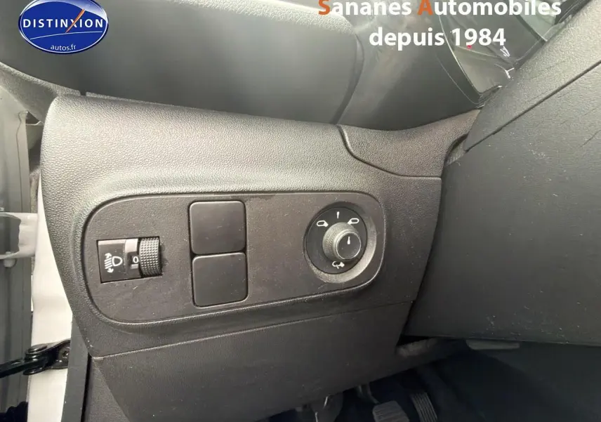 Détail des commandes d'éclairage côté gauche du tableau de bord noir d'une Citroën C3 2021 blanche toit rouge.