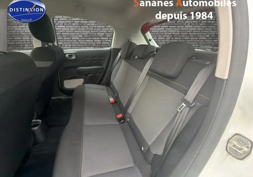 Vue intérieure côté droit montrant la banquette arrière en tissu gris et noir de la Citroën C3 blanc toit rouge.