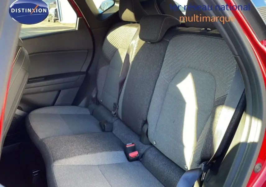 Vue côté droit sur les sièges arrière gris tissu du Renault Captur rouge Désir Métal avec toit noir, intérieur lumineux.