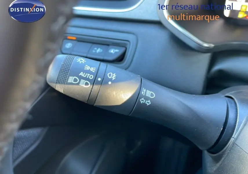 Gros plan sur la commande des phares et clignotants à gauche du volant dans l'habitacle du Renault Captur 2025.