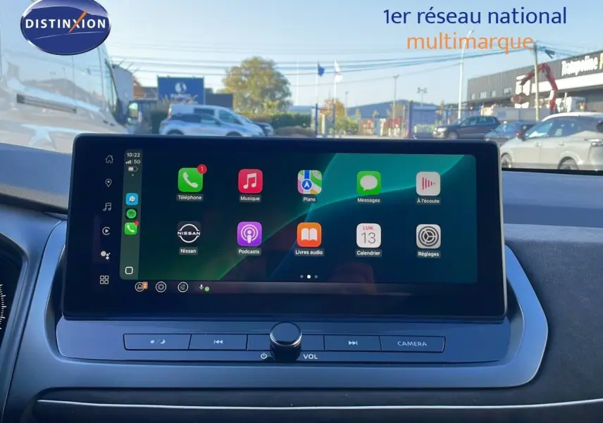 Écran tactile central du Nissan Qashqai blanc nacré 2025 affichant les applications Apple CarPlay en extérieur.