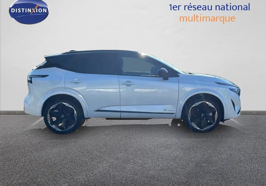 Profil droit du Nissan Qashqai 2025 blanc nacré avec toit noir et jantes noires distinctives en alliage.