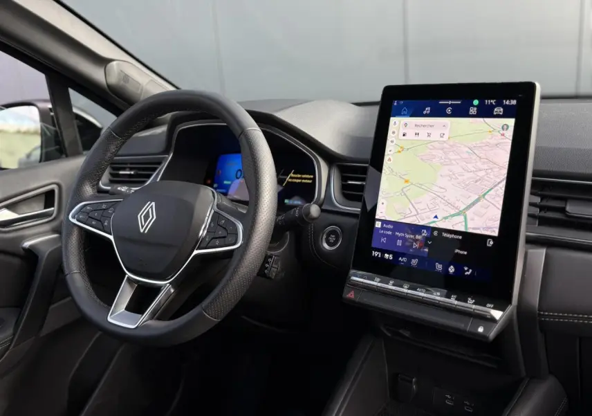 Vue intérieure côté conducteur du Renault SYMBIOZ 2025 avec volant multifonction et écran tactile vertical GPS.