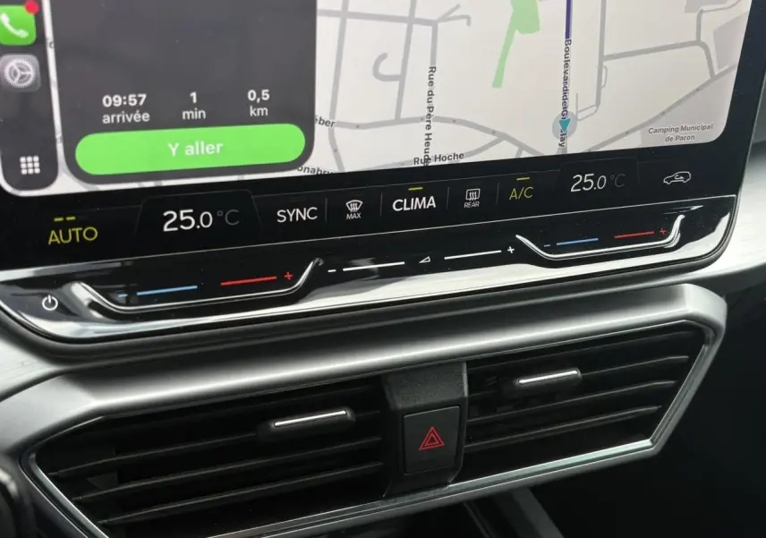 Gros plan sur la console centrale avec écran tactile et commandes climatisation du SEAT LEON 2025 Noir Minuit.