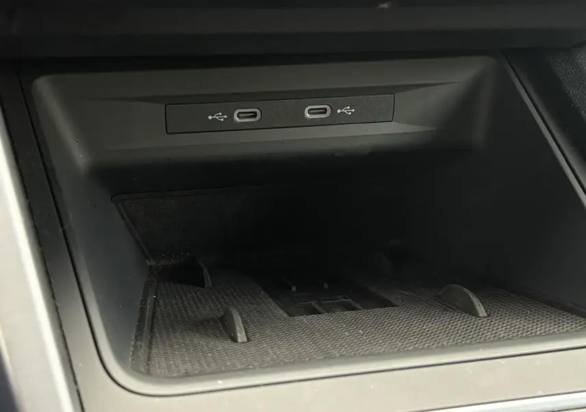 Gros plan sur la connectivité USB-C dans le rangement central du SEAT LEON 2025 noir Minuit.