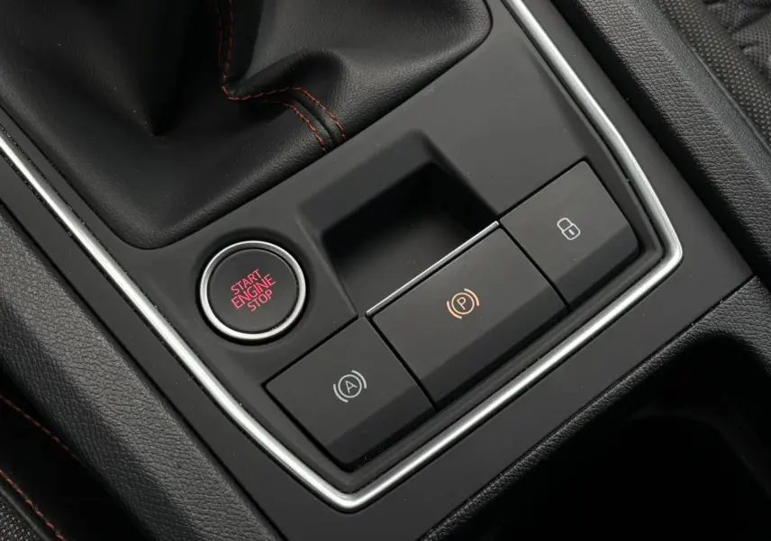 Gros plan sur la console centrale de la SEAT LEON 2025, avec bouton Start Engine Stop et commandes électroniques.