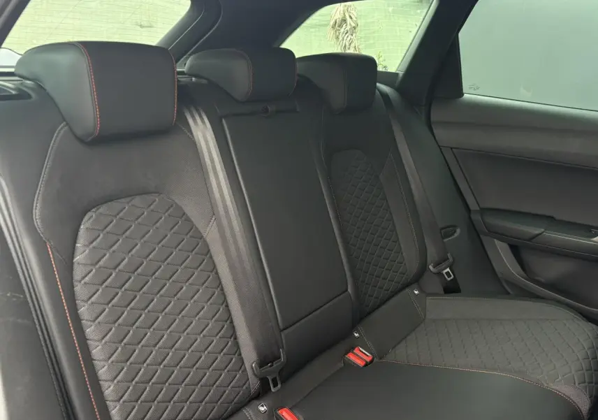 Vue latérale intérieure de la banquette arrière noire avec surpiqûres rouges du SEAT Leon 2025 version FR.