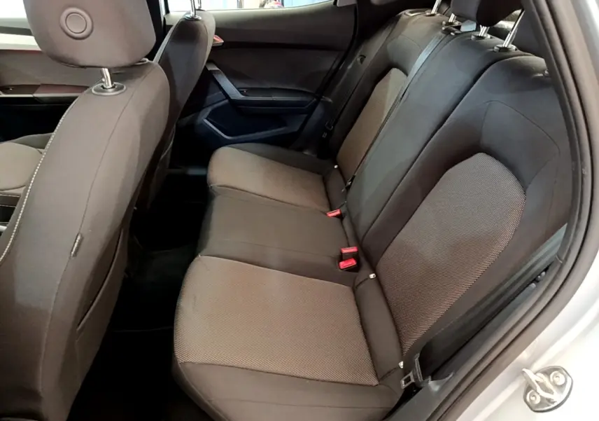 Vue intérieure côté droit sur la banquette arrière noire du SEAT Arona gris clair, avec ceintures et appuie-têtes visibles.