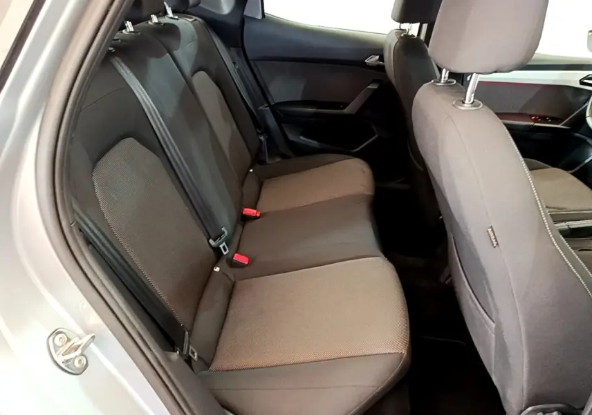 Vue intérieure côté gauche sur la banquette arrière grise du SEAT Arona 2019 avec sièges tissu et ceintures visibles.
