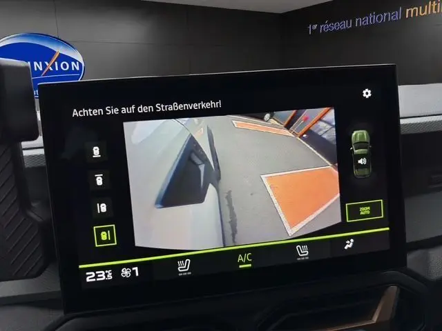 Écran intérieur du Dacia Duster 2025 montrant la caméra de recul avec vue sur le côté gauche blanc du véhicule.