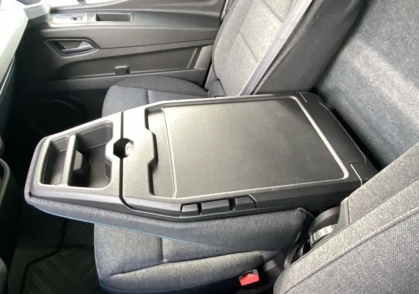 Vue rapprochée de l'accoudoir central noir et des sièges gris du Renault Master 2025, version utilitaire.