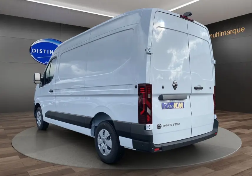 Renault Master blanc en 3/4 arrière droit, fourgon utilitaire avec feux arrière verticaux et bande noire latérale.
