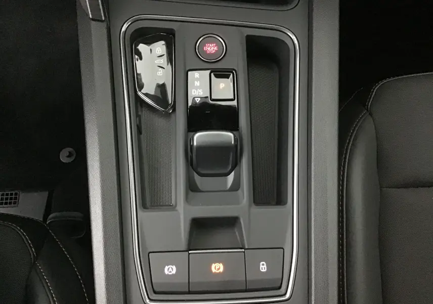 Vue plongeante sur la console centrale noire de la CUPRA Leon 2023, avec levier de vitesses DSG7 et bouton Start Engine Stop.