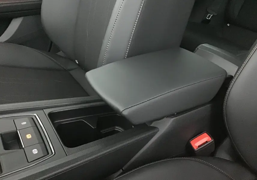 Accoudoir central en cuir noir avec console et commandes électroniques dans l'habitacle du Cupra Leon 2023.