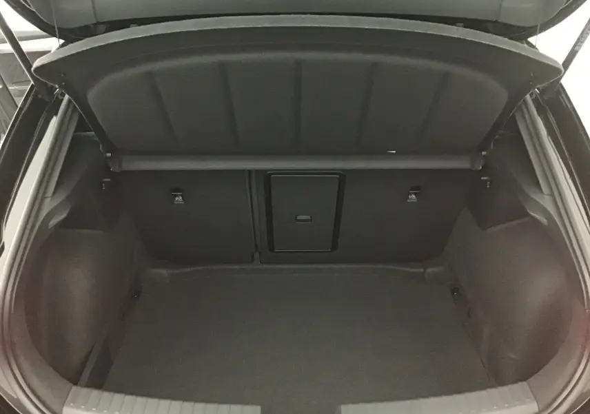 Coffre ouvert vu de l'arrière d'une CUPRA Leon noire 2023, montrant un espace de chargement propre et spacieux.