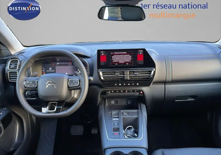 Vue intérieure frontale du tableau de bord et volant du Citroën C5 Aircross 2025 noir Perla Metal avec écran tactile central.