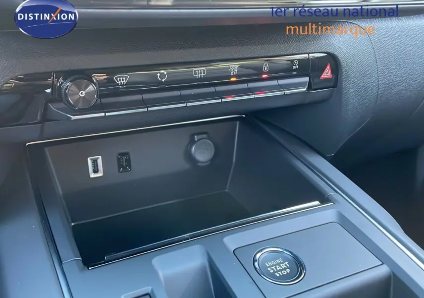 Vue rapprochée de la console centrale du Citroën C5 Aircross 2025 avec bouton start/stop et prises USB et 12V.