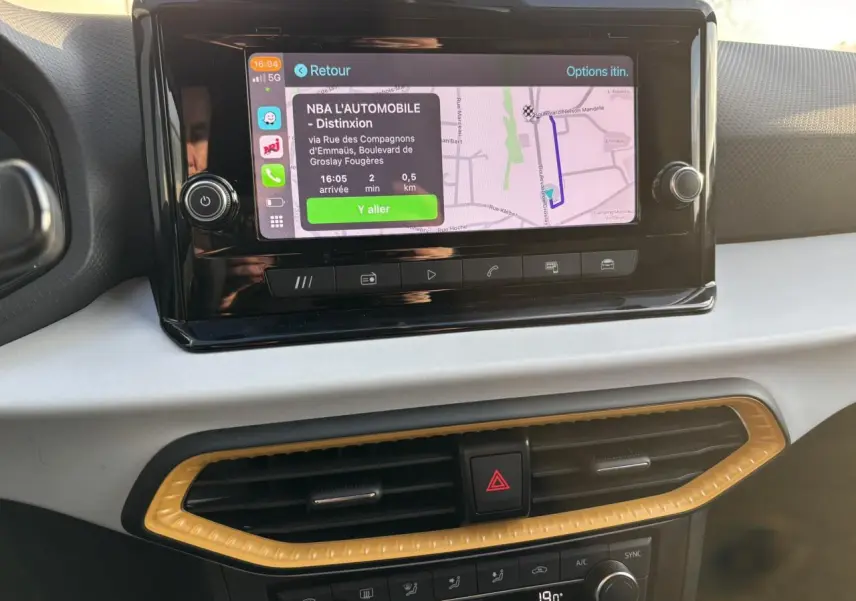 Vue rapprochée de l’écran tactile central et de la console de climatisation du SEAT Arona blanc, intérieur moderne.