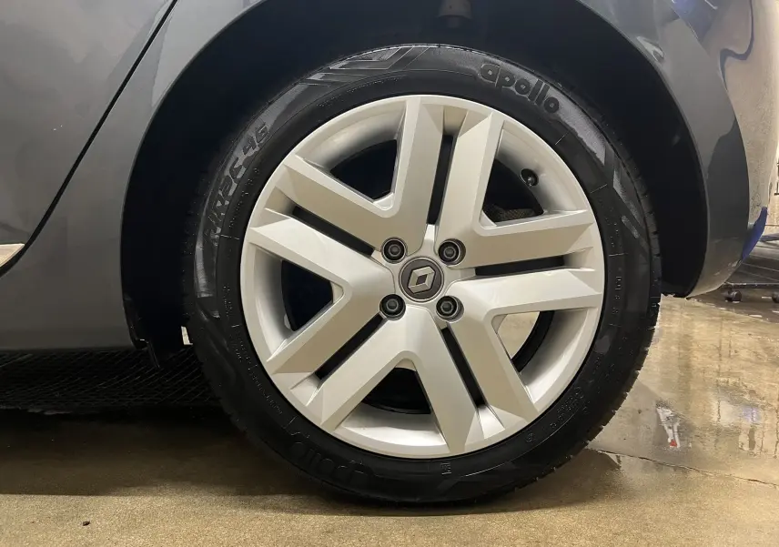 Gros plan sur la roue avant droite d'une Renault Clio V gris titanium avec jante alliage cinq branches.