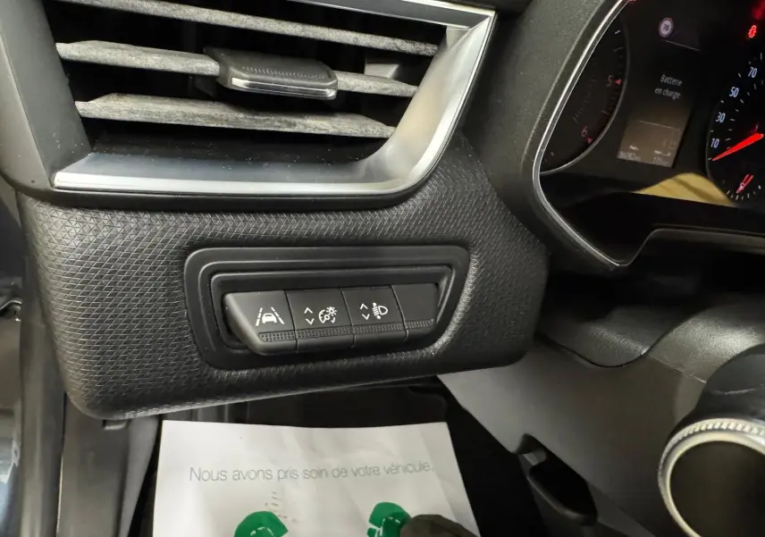 Détail intérieur côté gauche du tableau de bord de la Renault Clio V Business 2019, boutons de réglage et ventilation noire.