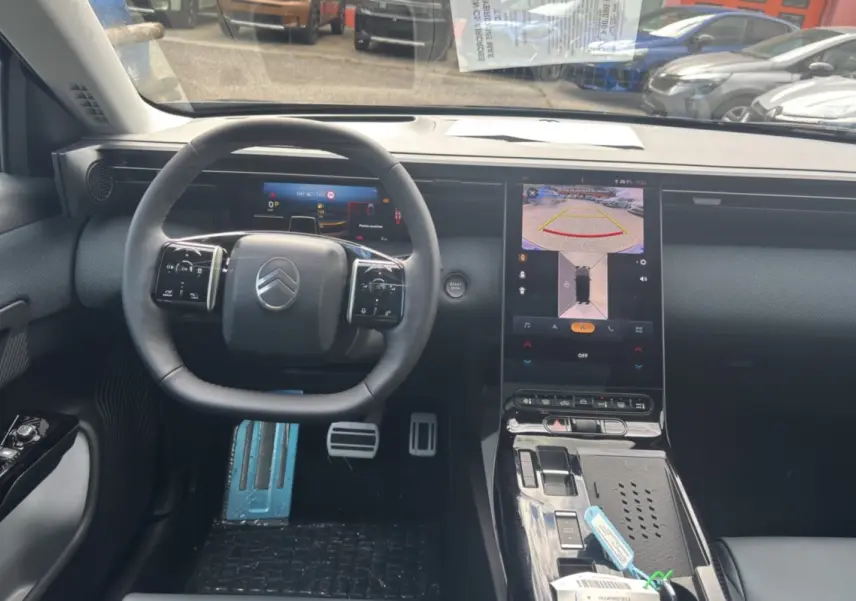 Vue intérieure du poste de conduite du Citroën C5 Aircross New Hybrid 2026, volant cuir multifonctions et écran tactile central allumé.