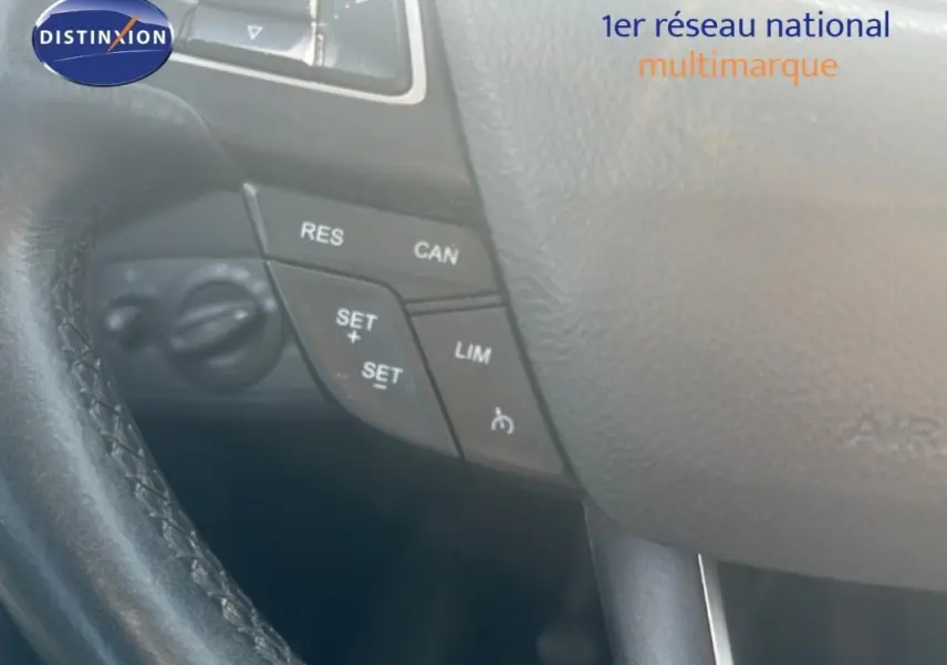 Gros plan sur le volant cuir noir du Ford Kuga 2019, avec commandes de régulateur de vitesse visibles.