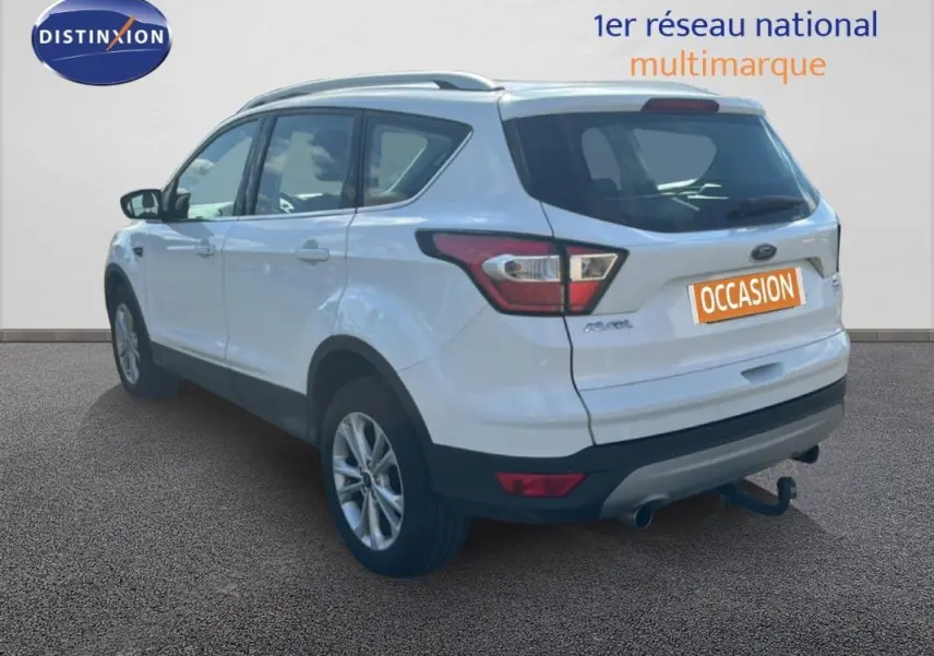 Vue 3/4 arrière droite d'un Ford Kuga blanc 2019 avec barres de toit et jantes alliage 17 pouces.