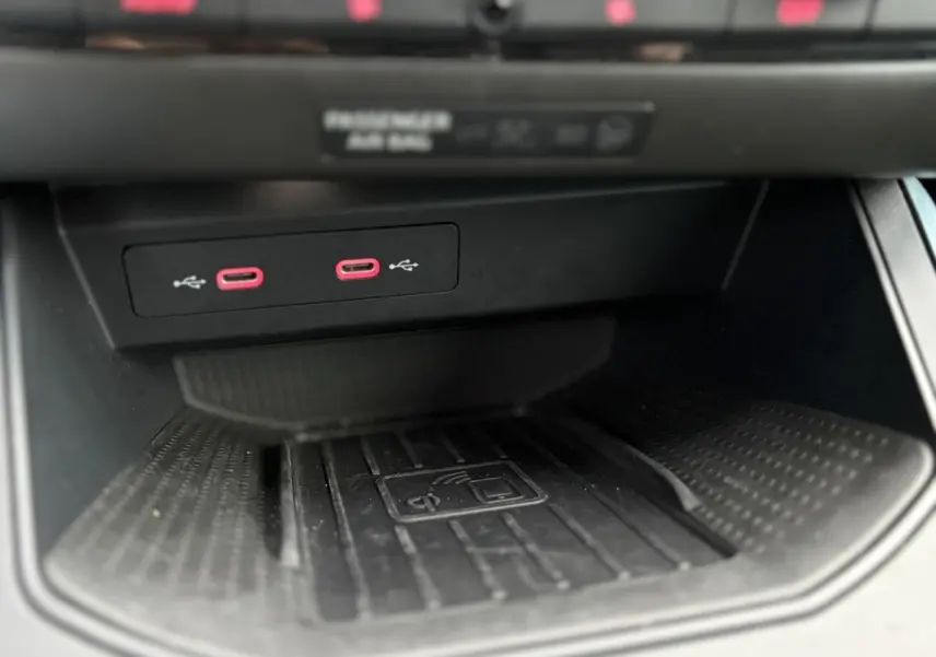 Gros plan sur la console centrale du SEAT Arona 2025, montrant deux ports USB-C rouges et un espace de charge sans fil noir.
