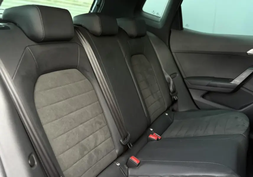 Vue intérieure côté gauche des sièges arrière en tissu noir et gris du SEAT Arona 2025.