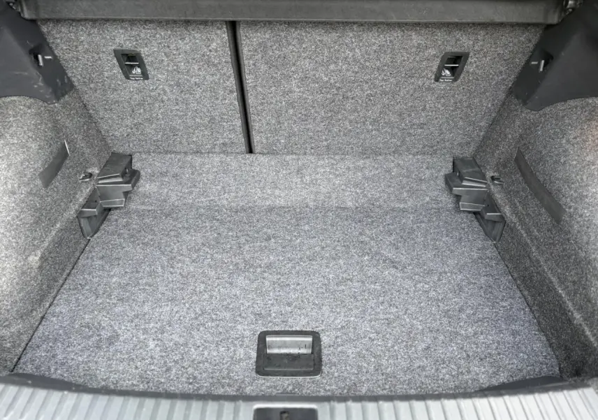 Coffre spacieux du SEAT Arona gris magnétique vu de face, avec revêtement gris et fixations ISOFIX visibles.