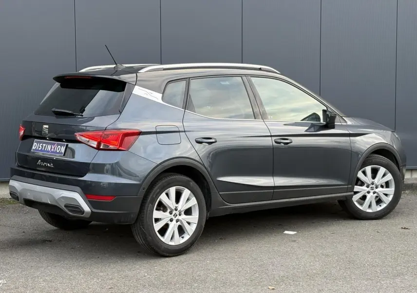 Vue 3/4 arrière droite d'un SEAT Arona gris magnétique avec toit contrasté et jantes alliage 17 pouces.