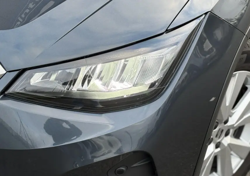 Gros plan sur le phare avant droit et la jante alliage du SEAT Arona 2025 en Gris Magnétique.