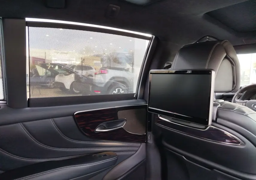 Intérieur arrière droit de la Lexus LS 500H 2020 gris manganèse, avec écran intégré au dossier et sellerie cuir noir.