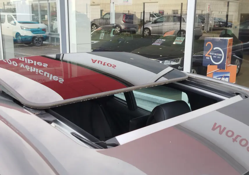 Toit ouvrant ouvert en vue plongeante sur une Lexus LS 500H gris manganèse, intérieur cuir noir visible.