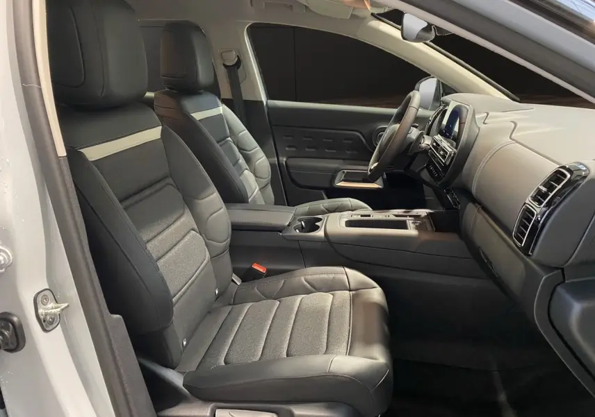 Intérieur noir du Citroën C5 Aircross 2024, vue côté gauche sur les sièges avant et le tableau de bord moderne.
