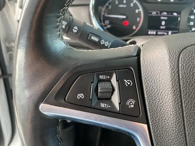 Gros plan sur les commandes de régulateur de vitesse au volant en cuir noir de l'Opel Mokka 2017.