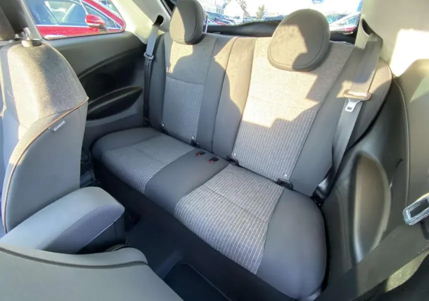 Vue intérieure arrière de la Fiat 500 électrique 2022, sièges bicolores gris et noir avec appuie-têtes ronds.