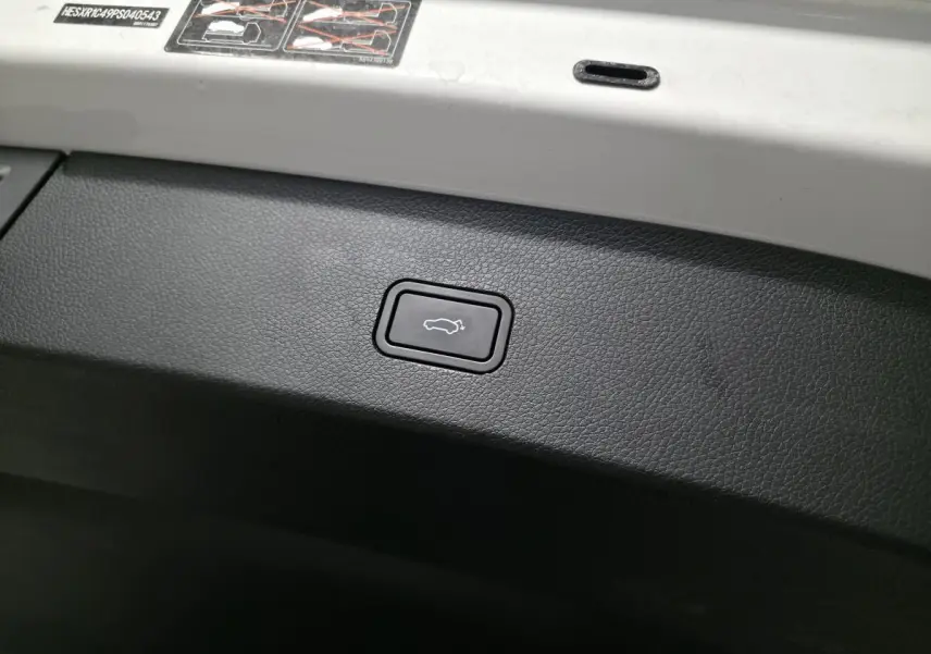 Bouton d'ouverture électrique du coffre sur panneau intérieur noir d'une Smart #1 blanche 2024.