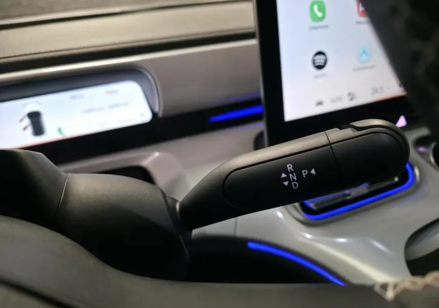 Le levier de boîte automatique noir du Smart #1 2024 visible côté conducteur avec écran tactile et éclairage bleu.