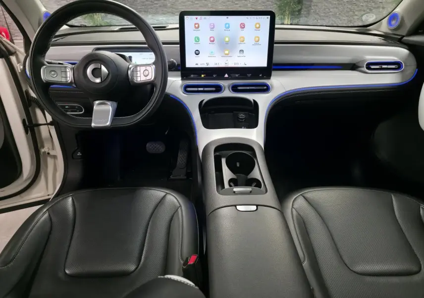 Intérieur de la Smart #1 2024 vu de face, avec tableau de bord blanc, écran tactile central et sièges cuir noirs.