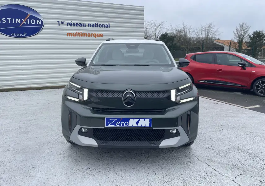 Vue de face du Citroën C3 Aircross hybride 2026 en vert Montana avec toit blanc, éclairage LED distinctif allumé.