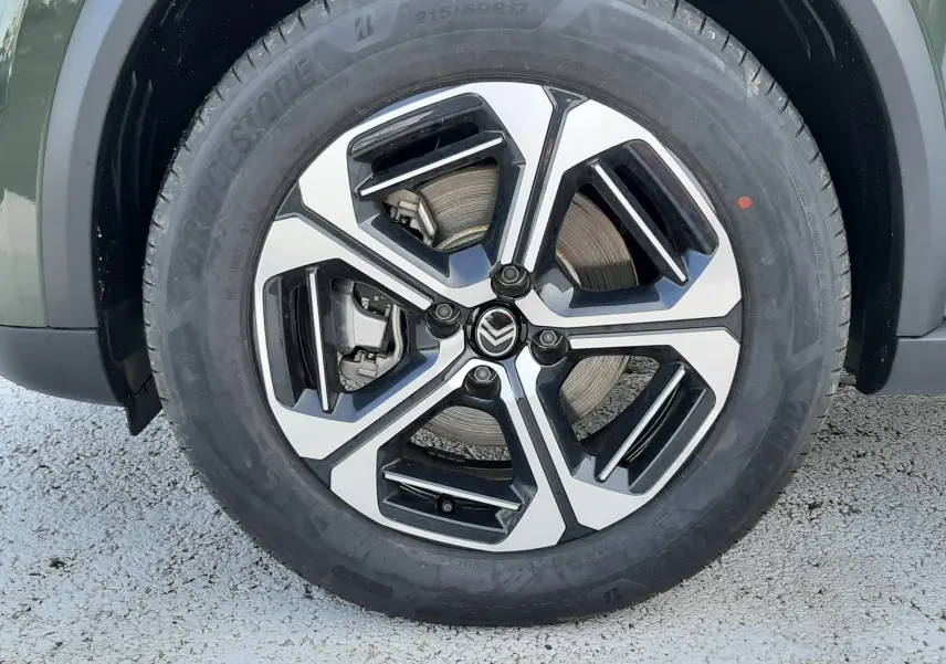 Gros plan sur la roue avant gauche de la Citroën C3 Aircross hybride 2026, jante alliage bicolore noire et argent.