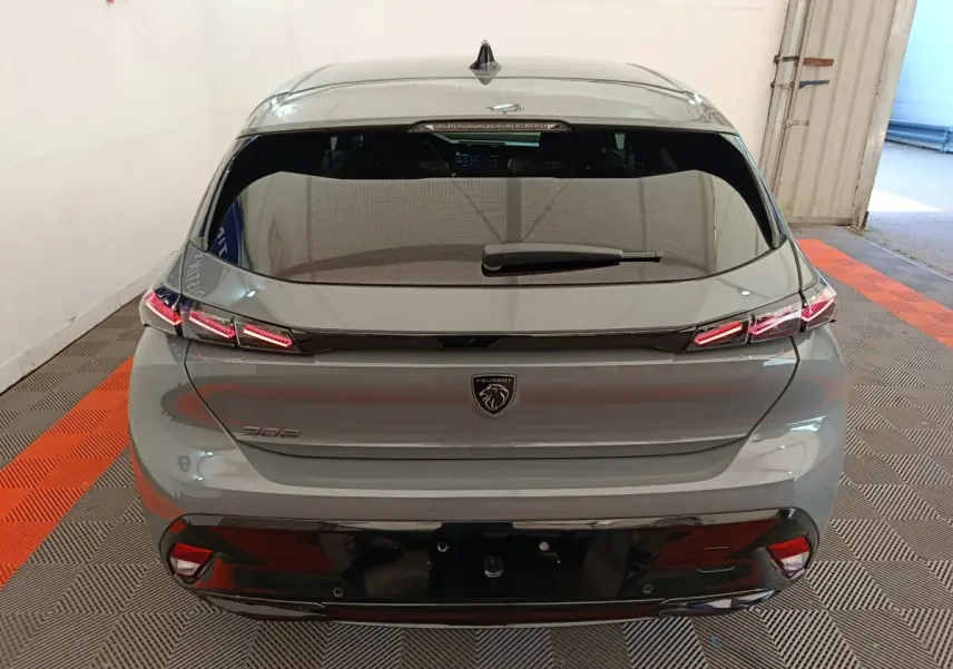 Vue arrière d'une Peugeot 308 gris foncé 2026 avec feux LED distinctifs et lunette arrière teintée.
