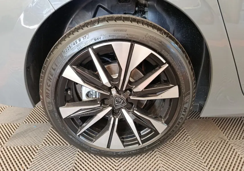 Gros plan sur la roue avant droite avec jante alliage bicolore de la Peugeot 308 gris foncé 2026.