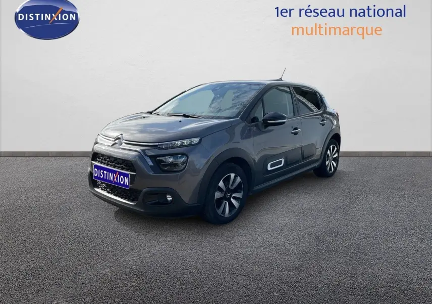 Citroën C3 gris platinium métal vue 3/4 avant droit avec protections latérales blanches et jantes bi-ton.